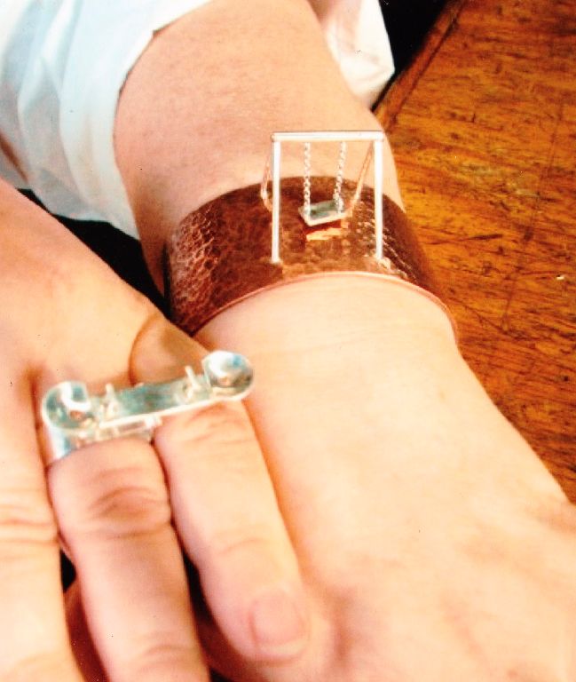 Playground Jewelry - left: silver ring with teeter-totter; right: copper bracelet with silver swing. Both operate.